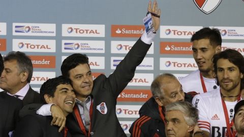 Argentina's River Plate coach Marcelo Gallardo raises his hand as he hugs a team member during the podium ceremony after winning the Copa Sudamericana soccer tournament in Buenos Aires, Argentina,  Wednesday, Dec. 10, 2014. Argentina's River Plate defeated Colombia's Atletico Nacional 2-0 in the final. (AP Photo/Victor R. Caivano)