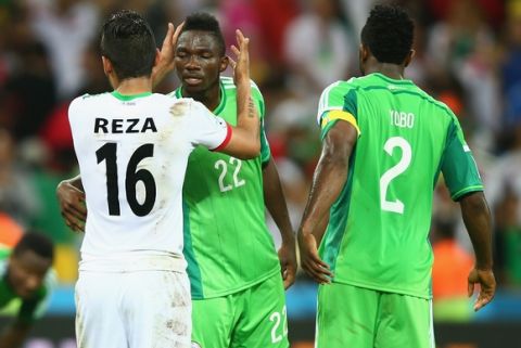 CURITIBA, BRAZIL - JUNE 16: Reza Ghoochannejhad of Iran reacts with Kenneth Omeruo of Nigeria after their draw during the 2014 FIFA World Cup Brazil Group F match between Iran and Nigeria at Arena da Baixada on June 16, 2014 in Curitiba, Brazil.  (Photo by Clive Rose/Getty Images)