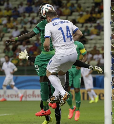 Ivory Coast's Cheik Tiote, left, and Greece's Dimitris Salpingidis go for a header during the group C World Cup soccer match between Greece and Ivory Coast at the Arena Castelao in Fortaleza, Brazil, Tuesday, June 24, 2014. (AP Photo/Fernando Llano)