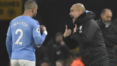 Manchester City's head coach Pep Guardiola, right, gives instructions to Kyle Walker during the English Premier League soccer match between Wolverhampton Wanderers and Manchester City at the Molineux Stadium in Wolverhampton, England, Friday, Dec. 27, 2019. (AP Photo/Rui Vieira)