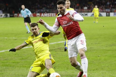 Arsenal's Sead Kolasinac, right, duels for the ball with Bate's Aleksei Rios during the Europa League round of 32 first leg soccer match between Bate and Arsenal at the Borisov-Arena in Borisov, Belarus, Thursday, Feb. 14, 2019. (AP Photo/Sergei Grits)
