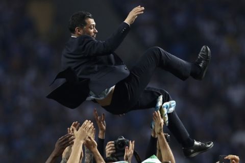 Porto coach Sergio Conceicao is thrown in the air by the players at the end of the Portuguese league soccer match between FC Porto and Feirense at the Dragao stadium in Porto, Portugal, Sunday, May 6, 2018. Porto clinched the league title Saturday night, two rounds before the end, when Benfica and Sporting CP tied 0-0 in their Lisbon derby. (AP Photo/Luis Vieira)