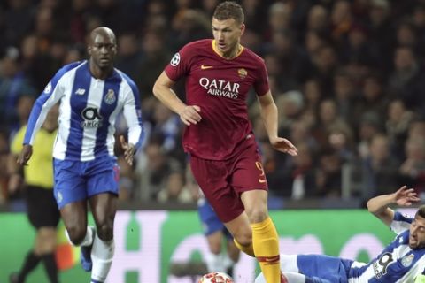 Roma forward Edin Dzeko runs with the ball away from Porto midfielder Hector Herrera, right, during the Champions League round of 16, 2nd leg, soccer match between FC Porto and AS Roma at the Dragao stadium in Porto, Portugal, Wednesday, March 6, 2019. (AP Photo/Luis Vieira)