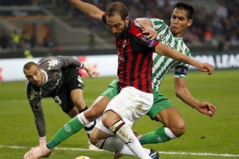 AC Milan's Gonzalo Higuain is challenged by Betis' Aissa Mandi, right, during the Europa League, Group F soccer match between AC Milan and Betis, at the San Siro Stadium in Milan, Italy, Thursday, Oct. 25, 2018. (AP Photo/Antonio Calanni)