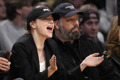 Actress Emma Stone, left, cheers during the second half of an NBA basketball game between the Los Angeles Lakers and the Phoenix Suns as she sits with director Yorgos Lanthimos Thursday, Jan. 11, 2024, in Los Angeles. (AP Photo/Mark J. Terrill)