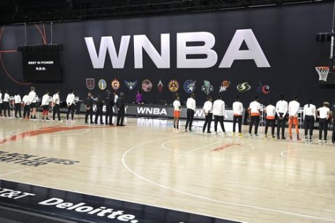 Members of the Las Vegas Aces, left, and the Connecticut Sun stand in honor of the passing of Supreme Court Justice Ruth Bader Ginsburg before Game 1 of a WNBA basketball semifinal round playoff game, Sunday, Sept. 20, 2020, in Bradenton, Fla. (AP Photo/Phelan M. Ebenhack)