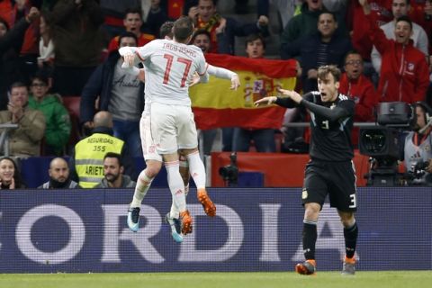 Spain's Iago Aspas, left, jumps to hug Spain's Isco Alarcon who scored his side's third goal as Argentina's Nicolas Tagliafico, right, reacts during the international friendly soccer match between Spain and Argentina at the Wanda Metropolitano stadium in Madrid, Spain, Tuesday, March 27, 2018. (AP Photo/Francisco Seco)