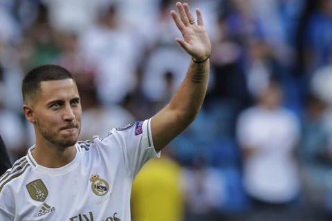Belgium forward Eden Hazard waves to supporters during his official presentation after signing for Real Madrid at the Santiago Bernabeu stadium in Madrid, Spain, Thursday, June 13, 2019. Real Madrid announced last week that it had acquired the 28-year-old Belgian playmaker from Chelsea for a reported fee of around 100 million euros ($113 million) plus variables, making him the club's most expensive signing ever. (AP Photo/Manu Fernandez)