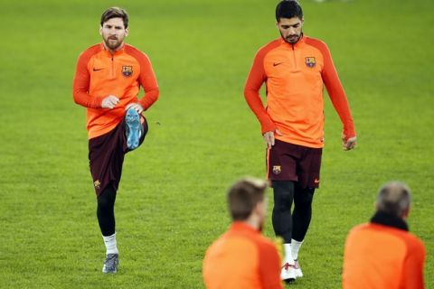 Barcelona's Lionel Messi, left, and Luis Suarez exercise during a training session at Stamford Bridge stadium in London, Monday, Feb. 19, 2018. FC Barcelona will play Chelsea in a Champions League round of sixteen first leg soccer match on Tuesday. (AP Photo/Alastair Grant)