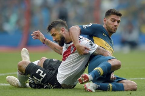 Lisandro Magallan of Argentina's Boca Juniors, right, tangles with Lucas Pratto of Argentina's River Plate during the first leg soccer match of the Copa Libertadores final in Buenos Aires, Argentina, Sunday, Nov. 11, 2018. (AP Photo/Gustavo Garello)