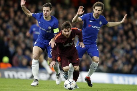 Barcelona's Lionel Messi, center, controls the ball as Chelsea's Cesar Azpilicueta, left, and his teammate Cesc Fabregas try to stop him during the Champions League, round of 16, first-leg soccer match between Chelsea and Barcelona at Stamford Bridge stadium, Tuesday, Feb. 20, 2018. (AP Photo/Frank Augstein)