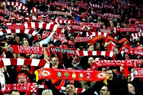 FILE - In this April 24, 2018 file photo, Liverpool fans sing "You'll Never Walk Alone" as they hold up scarves prior to the Champions League semifinal, first leg, soccer match between Liverpool and Roma at Anfield Stadium, Liverpool, England. The famous tune will be sung Saturday by 16,000-plus Liverpool fans at Olympic Stadium in Kiev, Ukraine. (AP Photo/Rui Vieira, File)