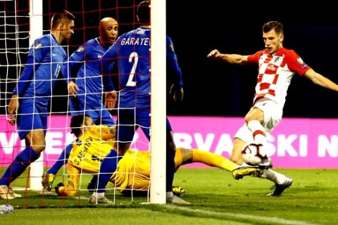 Croatia's Borna Barisic, right, scores his side's opening goal during the Euro 2020 group E qualifying soccer match between Croatia and Azerbaijan at the Maksimir stadium in Zagreb, Croatia, Thursday, March 21, 2019. (AP Photo/Darko Bandic)