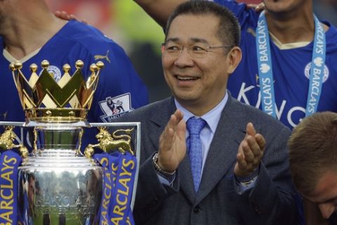 Vichai Srivaddhanaprabha applauds beside the trophy as Leicester City celebrate becoming the English Premier League soccer champions at King Power stadium in Leicester, England, Saturday, May 7, 2016.(AP Photo/Matt Dunham)