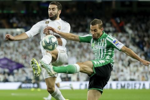 Betis' Sergio Canales vies for the ball with Real Madrid's Dani Carvajal, left, during a Spanish La Liga soccer match between Real Madrid and Betis at the Santiago Bernabeu stadium in Madrid, Saturday, Nov. 2, 2019. (AP Photo/Manu Fernandez)