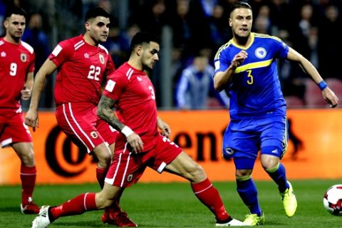 Bosnia's Ermin Bicakcic, right, challenges Gibraltar's Joseph Chipolina, center, during their World Cup Group H qualifying soccer match at the Bilino Polje Stadium in Zenica, on Saturday, March 25, 2017. (AP Photo/Amel Emric)
