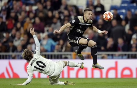 Real midfielder Luka Modric, left, tries to stop Ajax's Dusan Tadic during the Champions League round of 16 second leg soccer match between Real Madrid and Ajax at the Santiago Bernabeu stadium in Madrid, Tuesday, March 5, 2019. (AP Photo/Bernat Armangue)