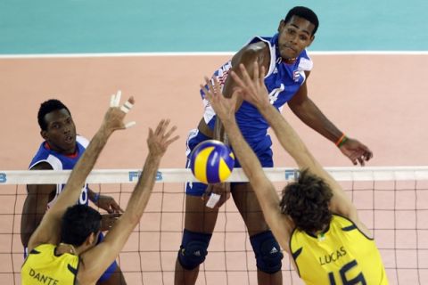 Cuba's Yoandy Leal Hidalgo spikes the ball past Brazil's Dante Guimaraes Amaral, left, and Lucas Saatkamp during the final match between Cuba and Brazil at the Men's Volleyball World Championships in Rome, Sunday, Oct. 10, 2010.  (AP Photo/Alessandra Tarantino)
