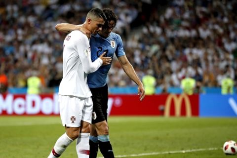Portugal's Cristiano Ronaldo helps injured Uruguay's Edinson Cavani walking out during the round of 16 match between Uruguay and Portugal at the 2018 soccer World Cup at the Fisht Stadium in Sochi, Russia, Saturday, June 30, 2018. (AP Photo/Francisco Seco)