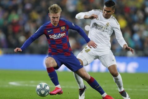 Barcelona's Frenkie de Jong, left, and Real Madrid's Casemiro compete for the ball during the Spanish La Liga soccer match at the Santiago Bernabeu stadium in Madrid, Spain, Sunday, March 1, 2020. (AP Photo/Manu Fernandez)