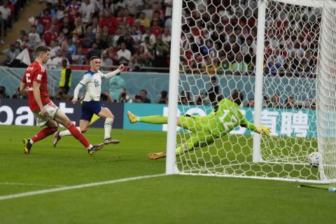 England's Phil Foden, center, scores past Wales' goalkeeper Danny Ward, right, his side's second goal during the World Cup group B soccer match between England and Wales, at the Ahmad Bin Ali Stadium in Al Rayyan , Qatar, Tuesday, Nov. 29, 2022. (AP Photo/Frank Augstein)