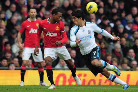 MANCHESTER, ENGLAND - FEBRUARY 11: Patrice Evra of Manchester United heads the ball away from  Luis Suarez of Liverpool during the Barclays Premier League match between Manchester United and Liverpool at Old Trafford on February 11, 2012 in Manchester, England.  (Photo by Shaun Botterill/Getty Images)