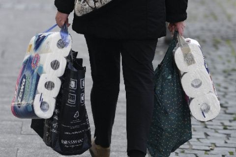 A woman carries her shopping including bags of toilet paper, in downtown Frankfurt, Germany, Wednesday, March 18, 2020. Because of the spread of the coronavirus, bars, cinemas, theatres, museums, and many shops are now closed. For most people, the new coronavirus causes only mild or moderate symptoms. For some it can cause more severe illness. (Arne Dedert/dpa via AP)