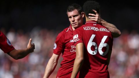 Liverpool's James Milner, center, embraces Liverpool's Trent Alexander-Arnold at the end of the English Premier League soccer match between Liverpool and Wolverhampton Wanderers at the Anfield stadium in Liverpool, England, Sunday, May 12, 2019. Despite a 2-0 win over Wolverhampton Wanderers, Liverpool missed out on becoming English champion for the first time since 1990 because title rival Manchester City beat Brighton 4-1. (AP Photo/Dave Thompson)