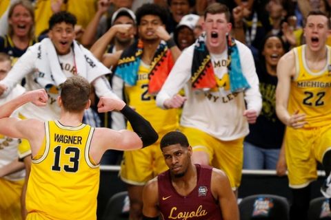 Michigan's Moritz Wagner (13) celebrates with his teammates as Loyola-Chicago's Aundre Jackson (24) walks off during the second half in the semifinals of the Final Four NCAA college basketball tournament, Saturday, March 31, 2018, in San Antonio. (AP Photo/Brynn Anderson)