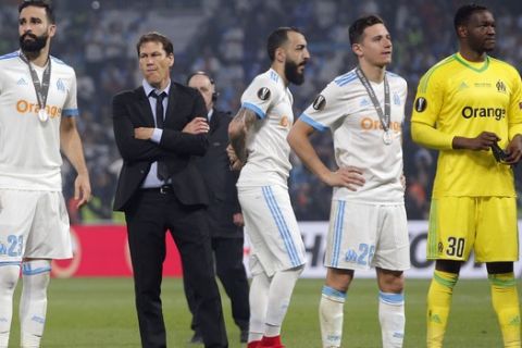 From left, Marseille's Adil Rami, Rudi Garcia, Konstantinos Mitroglou, Florian Thauvin, and Steve Mandanda, stand on the pitch after their defeat during the Europa League Final soccer match between Marseille and Atletico Madrid at the Stade de Lyon in Decines, outside Lyon, France, Wednesday, May 16, 2018. (AP Photo/Thibault Camus)