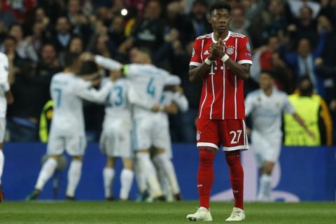 Bayern's David Alaba reacts when Madrid players celebrate after scoring their second goal during the Champions League semifinal second leg soccer match between Real Madrid and FC Bayern Munich at the Santiago Bernabeu stadium in Madrid, Spain, Tuesday, May 1, 2018. (AP Photo/Paul White)