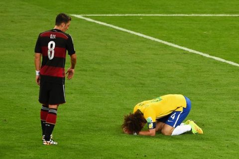 BELO HORIZONTE, BRAZIL - JULY 08:  David Luiz of Brazil reacts after being defeated 7-1 by Germany as Mesut Oezil of Germany looks on during the 2014 FIFA World Cup Brazil Semi Final match between Brazil and Germany at Estadio Mineirao on July 8, 2014 in Belo Horizonte, Brazil.  (Photo by Jamie McDonald/Getty Images)