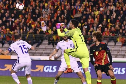 Greece's goalkeeper Stefanos Kapino, center, punches away the ball after a shot on goal by Belgium's Marouane Fellaini, right, during the Euro 2018 Group H qualifying match between Belgium and Greece at the King Baudouin stadium in Brussels on Saturday, March 25, 2017. (AP Photo/Geert Vanden Wijngaert)