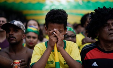 A Brazil soccer fan cover his face as he watches a live broadcast of the Russia World Cup quarterfinal match between his team and Belgium in Rio de Janeiro, Brazil, Friday, July 6, 2018. (AP Photo/Leo Correa)