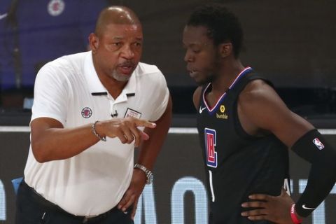Los Angeles Clippers head coach Doc Rivers (left) talks with guard Reggie Jackson (1) during the second half of Game 2 of an NBA basketball first-round playoff series, Wednesday, Aug. 19, 2020, in Lake Buena Vista, Fla. (Kim Klement/Pool Photo via AP)