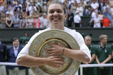 Romania's Simona Halep poses with the trophy after defeating United States' Serena Williams during the women's singles final match on day twelve of the Wimbledon Tennis Championships in London, Saturday, July 13, 2019. (AP Photo/Kirsty Wigglesworth)