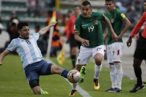 Argentina's Enzo Perez, left, and Bolivia's Mauricio Chajtur vie for the ball during a 2018 World Cup qualifying soccer match in La Paz, Bolivia, on Tuesday, March 28, 2017. (AP Photo/Victor R. Caivano)