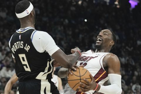 Milwaukee Bucks' Bobby Portis draws a charge on Miami Heat's Bam Adebayo during the first half in Game 1 of an NBA basketball first-round playoff game Sunday, April 16, 2023, in Milwaukee. (AP Photo/Morry Gash)