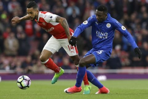 Arsenal's Theo Walcott, left, vies with Leicester City's Wilfred Ndidi during the English Premier League soccer match between Arsenal and Leicester City at the Emirates Stadium in London, Wednesday, April 26, 2017. (AP Photo/Alastair Grant)