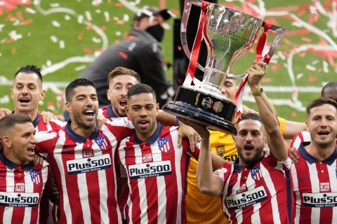Atletico Madrid players celebrate with the trophy at the Wanda Metropolitano stadium in Madrid, Spain, Sunday, May 23, 2021. Atletico Madrid survived a dramatic final round to clinch its first Spanish league title since 2014 with a 2-1 come-from-behind win at Valladolid on Saturday. (AP Photo/Manu Fernandez)