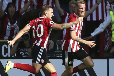 Sheffield United's Oliver McBurnie, right, celebrates scoring his side's first goal of the game with team mates during the English Premier League soccer match between Sheffield United and Leicester City at Bramall Lane stadium, Sheffield, England. Saturday, Aug, 10 2019. (Richard Sellers/PA via AP)