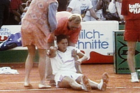 Monica Seles sits on the ground as she is aided by two helpers, bottom, while others grab a man, unseen behind Seles, who leaned out of the stands at the Hamburg tennis tournament on April 30, 1993 and stabbed the world?s top-ranked tennis player when she sat taking a break. Seles was taken to hospital but police said her life was not in danger. (AP Photo)