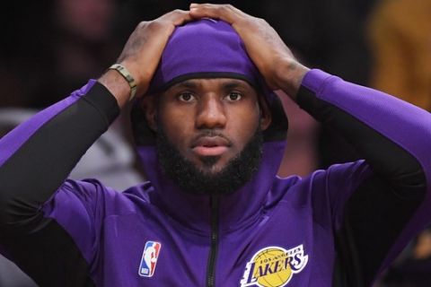 Los Angeles Lakers forward LeBron James sits on the bench during the first half of a preseason NBA basketball game against the Golden State Warriors, Monday, Oct. 14, 2019, in Los Angeles. (AP Photo/Mark J. Terrill)