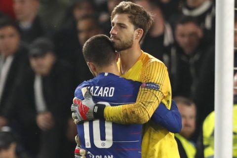 Chelsea's Eden Hazard hugs Frankfurt goalkeeper Kevin Trapp after scoring the winning penalty in a shootout during the Europa League semifinal second leg soccer match between FC Chelsea and Eintracht Frankfurt at Stamford Bridge stadium in London, Thursday, May 9, 2019. (AP Photo/Alastair Grant)