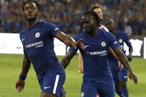 Chelsea's Michy Batshuayi, left, celebrates with teammate Victor Moses after scoring a goal during the first half of their friendly soccer match against Arsenal in Beijing, Saturday, July 22, 2017. Chelsea beat Arsenal 3-0. (AP Photo/Mark Schiefelbein)