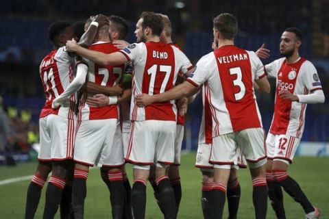 Ajax's Hakim Ziyech celebrates with teammates after Chelsea's goalkeeper Kepa Arrizabalaga scores an own goal during the Champions League, group H, soccer match between Chelsea and Ajax, at Stamford Bridge in London, Tuesday, Nov. 5, 2019. (AP Photo/Ian Walton)
