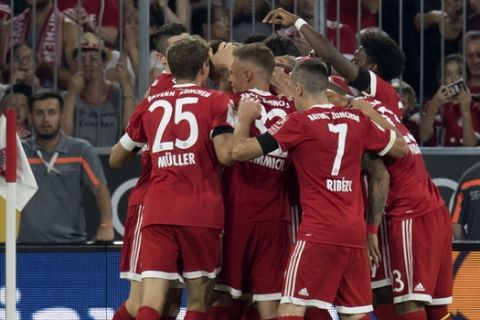 Bayern Munich players celebrate a goal by teammate Niklas Suele during the German Bundesliga soccer match against Bayer Leverkusen in the Allianz Arena in Munich, Germany, Friday Aug. 18, 2017. (Sven Hoppe/dpa via AP)