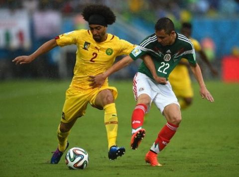NATAL, BRAZIL - JUNE 13:  Benoit Assou-Ekotto of Cameroon holds off Paul Aguilar of Mexico in the first half during the 2014 FIFA World Cup Brazil Group A match between Mexico and Cameroon at Estadio das Dunas on June 13, 2014 in Natal, Brazil.  (Photo by Matthias Hangst/Getty Images)