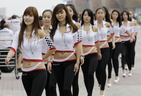 The grid girls for the Korean Grand Prix walk down the F1 Paddock in Yeongam, South Korea, Saturday, Oct. 23, 2010. Yeongam will be host to Korea's first Formula One race on Sunday Oct 24. (AP Photo/Lee Jin-man )