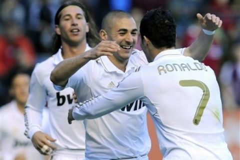 Real Madrid's Karim Benzema from France, center, is congratulated by his fellow teammate Cristiano Ronaldo from Portugal , right, after he scored against Osasuna, during their Spanish La Liga soccer match, at Reyno de Navarra stadium in Pamplona, northern Spain, Saturday March 31, 2012. (AP Photo/Alvaro Barrientos)